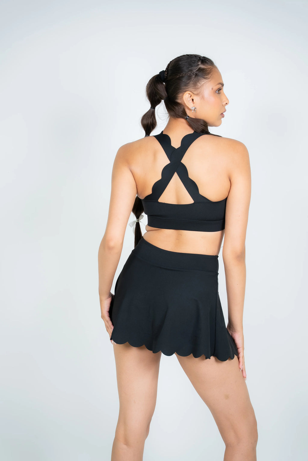 Black scallop hem activewear skirt by Soi on white studio background